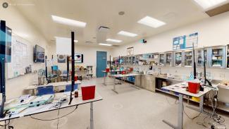 The training room includes several tables set up with simulation equipment for learning how to safely and humanely handle rodents.